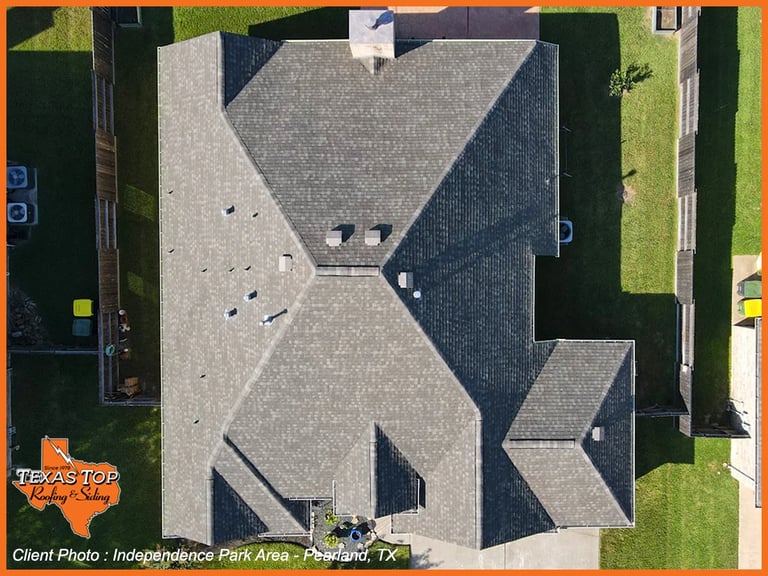 Aerial view of a residential roof with geometric gray and dark shingles in Texas